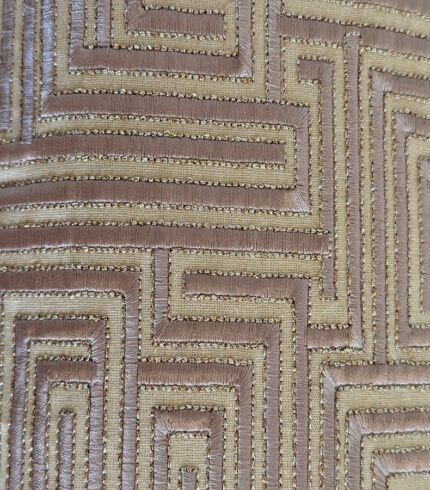 Zoom auf einen gold- und cremefarbenen Baumwollkissenbezug mit gestepptem Muster eines Labyrinths