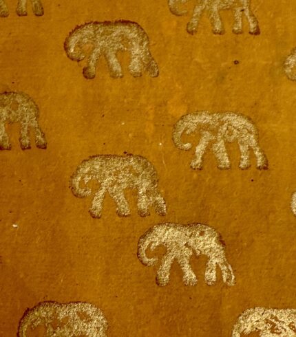 Zoom in ein handgemachtes, honigbraunen Papiers mit goldenem Motiv eines Elefanten