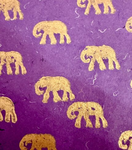 Zoom in ein handgemachtes, dunkelviolettes Papiers mit goldenem Motiv eines Elefanten
