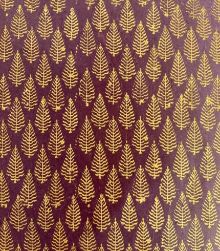 Frontalansicht eines handgemachten, violetten Papiers mit goldenem Motiv, das einem Weihnachtsbaum ähnelt