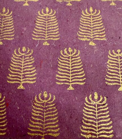 Zoom in ein handgemachtes, violettes Papier mit goldenem Motiv, das einem Baum ähnelt