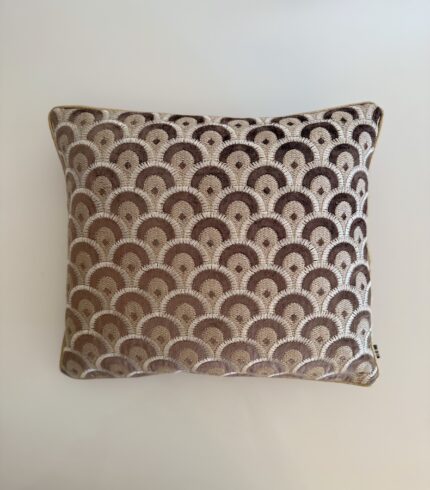 Ein dunkelbrauner Kissenbezug mit gold und cremefarbenen Applikationen in Pfaufederform