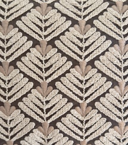 Zoom auf ein Kissenbezugmuster mit braunem Baumwollhintergrund bestickte Applikationen aus Lotusblüten in creme und weiss