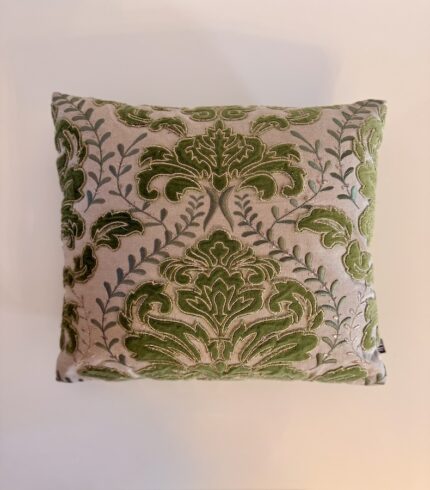 Ein cremefarbener Baumwollkissenbezug mit grünen Lorbeerapplikationen