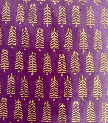 Frontalansicht eines handgemachten, violetten Papiers mit goldenem Motiv, das einem Baum ähnelt
