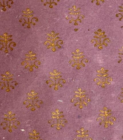 Zoom in ein handgemachtes, lavendelfarbenes Papier mit goldenem Motiv, das einem Weihnachtsbaum ähnelt