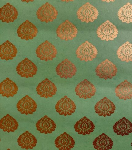 Frontalansicht eines handbedruckten, grasgrünen Papiers mit gold schimmernden Ornamenten