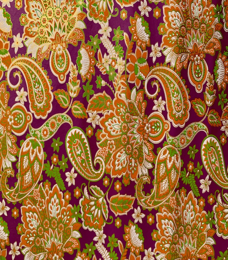 P014_1 Frontalansicht eines handbedruckten, dunkelvioletten Papiers mit kräftigen orangefarbenen Blütenornamenten unterbrochen von grasgrünen und weissen Blütenblättern
