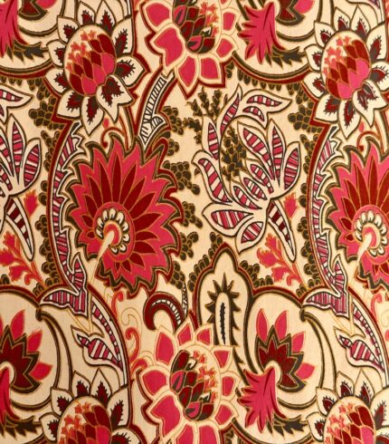 Zoom in ein handbedrucktes, cremefarbenes Papiers mit kräftigen rosafarbenen Blütenornamenten