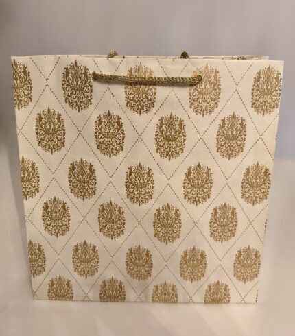 Frontalansicht einer handgemachten, cremefarbenen Papiertragetasche mit goldenen Ornamenten in einem symmetrischen Raster angeordnet